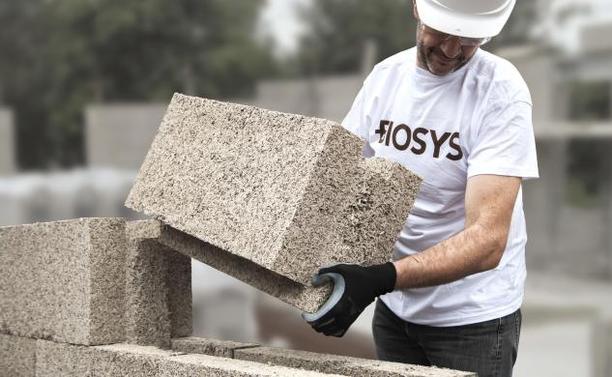 Guy stacking up an interlocking hemp lime block wall.