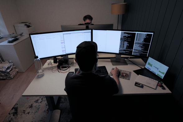Unser CTO Andri, der an seinem Arbeitsplatz vor einem doppeltem Bildschirm sitzt.