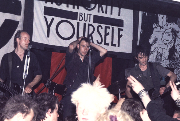 Crass in der Cleatormoor Civic Hall, Cumbria, England, 3. Mai 1984
Von links nach rechts: Pete Wright (Bass), Steve Ignorant (Gesang), N.A. Palmer (Gitarre)