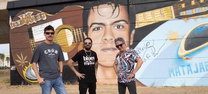Los Delinqüentes junto al grafiti de Fran Cosa V. / JUAN CARLOS TORO