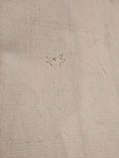 Page de papier. On devine un filigrane en forme de dragon qui a été encré en partie