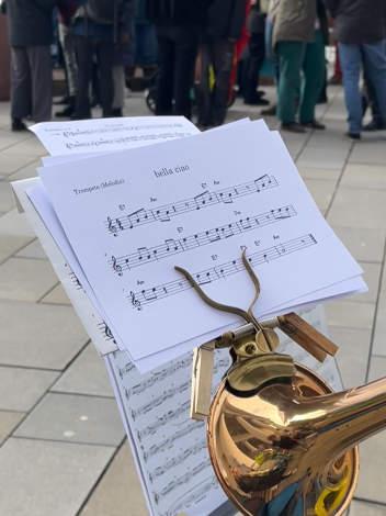 Nahaufnahme einer Trompeten-Marschgabel mit aufliegenden Noten von Bella Ciao.