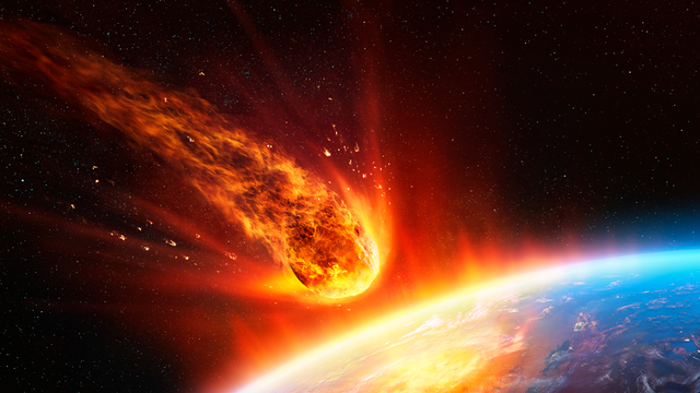 A fiery meteor hurtles towards a blue planet, trailing bright flames and sparks against a starry backdrop.