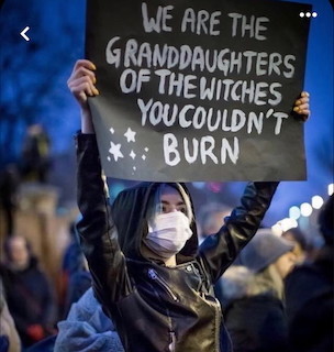 A young woman holding up a large poster that reads:
We are the granddaughters of the witches you couldn't burn!
(Marlena Kuczko - Poland)