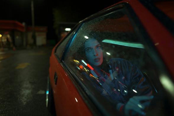 Unsplash photo of a young woman sitting in the back of a red car looking outward & upward with an inscrutable expression on her face. The tightly cropped frame shows the right rear side of the car, and a soft-focus dark city background. Streaks of colored lights reflect in the glass of the window through which we see the woman. Mood is somewhat mysterious, a story unfolding but we don't have enough context. 
Captioned, "woman in black jacket sitting on red car /
Catching lights reflections" 

Saint Petersburg, Russia 
Dated 2021 Sep 12, by Maksim Istomin. 
www.Unsplash.com/photos/woman-in-black-jacket-sitting-on-red-car-VhDkWkzV4Z0 

www.KronoMoon.org 🏳️‍🌈 ☮️ 
#KronoWatch