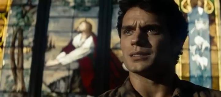 A scene from the movie "Man of Steel" with star Henry Cavill speaking while standing in front of the same stained glass window. He is just to the right of the image of the kneeling Jesus.