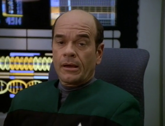Doctor from Star Trek Voyager, sitting in a chair, looking decidedly weary and tired.