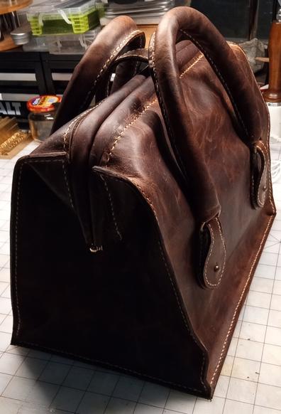 A side view of the bag showing how the top creases inward when the frame mechanism is closed.