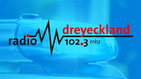 Logo von Radio Dreyeckland. 102,3 Megahertz Schwarze und rote Schrift auf blauem Grund.