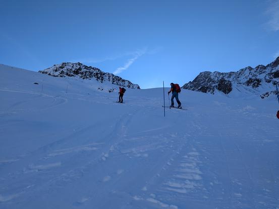 Two skiers scaling up the snowy hill.