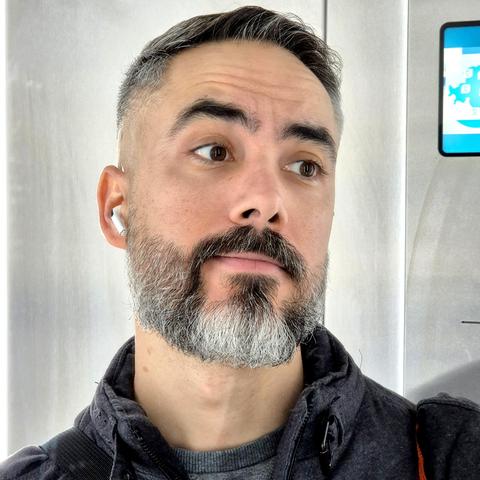 Fotografía frente al espejo del ascensor con la cara mirando ligeramente hacia el lado después de haberme ido a cortar el pelo y arreglarme la barba.