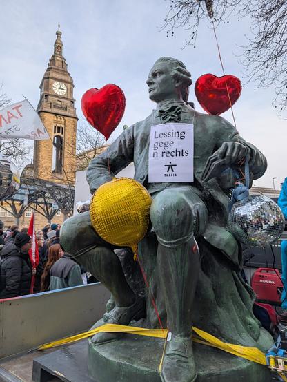 Eine mit bunten Ballons  geschmückte Lessing-Statue auf einem Demo-Musikwagen ("Lessing gegen rechts")