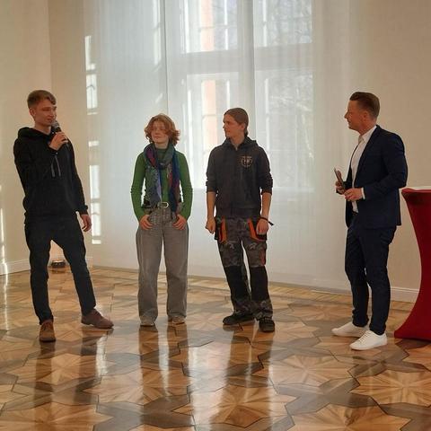 Drei junge Menschen der EJN zusammen mit einem Moderator bei der Vorstellung des Projektes.