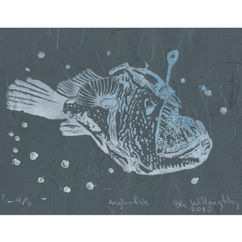 My linocut print of an anglerfish side profile with jaws agape in white with a hint of blue, and some bubbles, on Japanese dark blue/Payne’s grey cloud unryu paper with visible swirling fibres