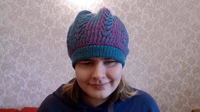 Photo of the same hat from the front. The woman is smiling towards the camera.