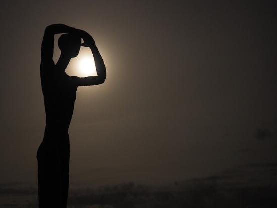 Die Skulptur names Utkieker bei Nacht mit dem Mond im Hintergrund.