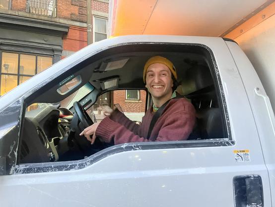 Me wearing a red sweater and driving a 12 foot tall and 30 foot box truck in downtown Brooklyn