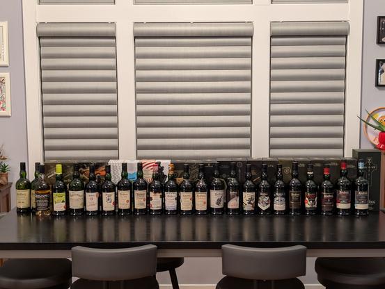Both rows of Ardbeg bottles on a table, 44 in all