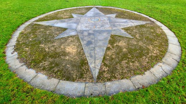 A compass rose set into the ground of a Glasgow park.