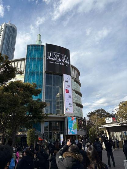 A blue sky and a tower. The viewer is looking up. There is a tower with the words, LUNA SEA.