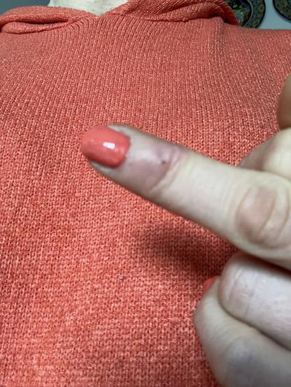 Mittelfinger mit orangenem Nagellack