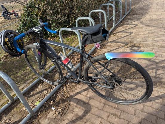 Ein Fahrrad mit Helm am Lenker an einem Fahrräder angelehnt und angeschlossenen