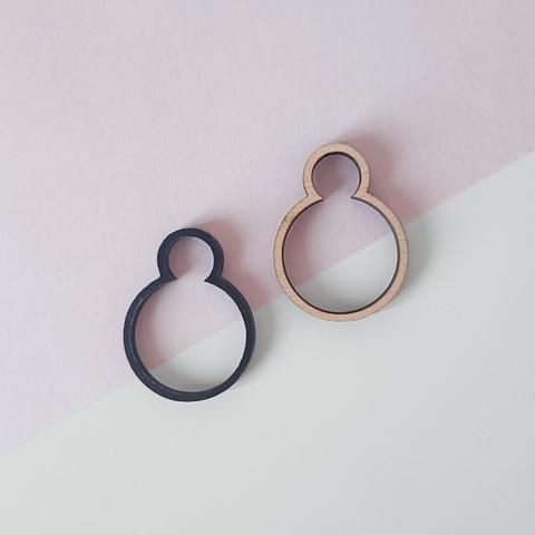 Houten en zwarte kunststof ring met geometrische ronde vormen