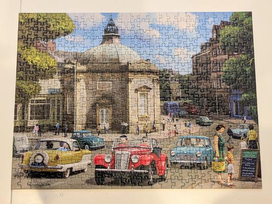 Completed jigsaw puzzle featuring an illustrated scene set in Harrogate, looks like the 60s. There are a few colourful cars in the foreground, buildings and trees around the edges, but the majority of the puzzle is taken up with a large domed building on a street corner.