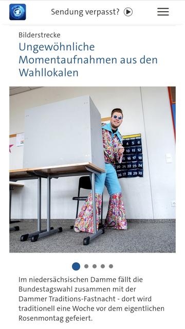 Ein kostümierter Mann kommt aus einer Wahlkabine