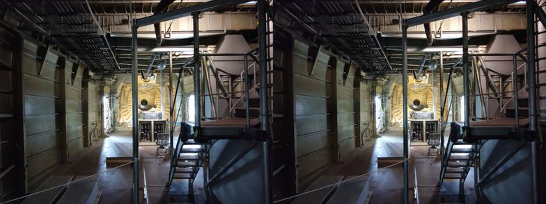 Stereoscopic, parallel view. Interior of an enormous seaplane, looking forward toward the prow. Doesn't recede from our view as far as the previous view, as there is a bulwark a few meters back. A set of stairs on the right goes (presumably) to the cockpit.