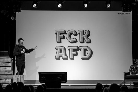 Me presenting on stage showing a color font. The slide shows "FCK AFD" in large type.
