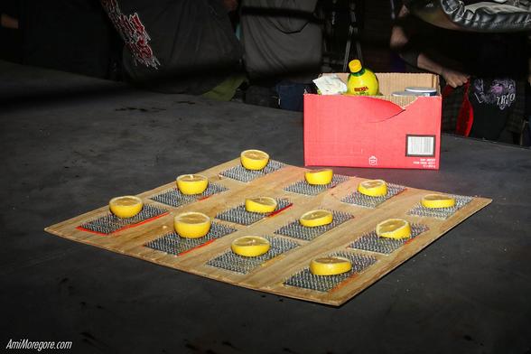 sliced lemons on gusset plates on a wooden board with a box full of lime juice and obscured salt cartons
