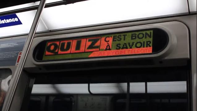 LED display (in 2010) affixed above the window inside a subway train showing a green, orange and black graphic that says “Quiz. C’est bon à savoir”