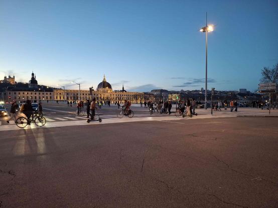 carrefour du pont de la Guillotière avec une nuée de personnes en mode actif faisant la traversée.
en arrière plan le grand hôtel dieu et la basilique de Fourvière