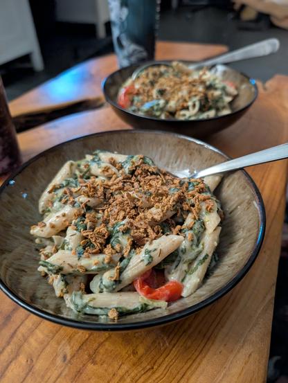 Zwei Schalen mit Nudeln in Sauce und Crumble on top