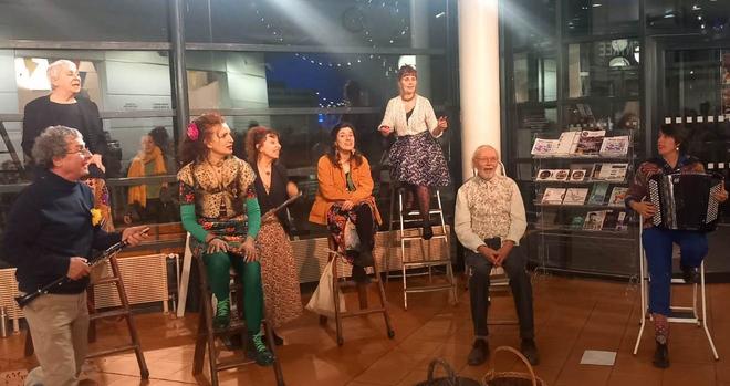 Chorale sur escabeaux dans le hall du Polaris, au premier rang de gauche à droite : guy prunier, frida morrone, agathe meusnier, paul pons, hélène subtil à l'accordéon, derrière elisabeth calandry, françoise danjoux, annie gallay.