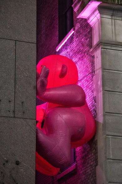 A large, pink inflatable figure is partially wedged between two buildings. The figure appears to be making a peace sign, illuminated by pink lights. The surrounding architecture features a mix of textured gray and brick walls.

Mr. Pink 4
by Philippe Katerine

Mignonisme (Cuteism) is a poetically off-kilter movement to embrace the aesthetics of “cuteness” in our physical and psychological environments. Philippe Katerine presents a series of inflatable sculptures in public spaces, all featuring “Monsieur Rose” (Mr. Pink). The monumental icon of Mignonisme can be found perched on rooftops around the city. These characters transform the streets into playful places and our daily travels into delightful, colorful journeys.