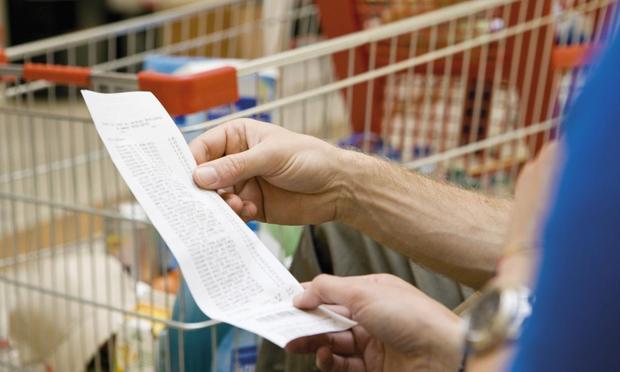 Imagen de archivo de una persona consultado un ticket de la compra en un supermercado. (Philippe Dureuil via Getty Images)