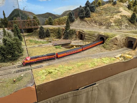 A modern Southern Pacific diesel pulling a string of Daylight passenger cars