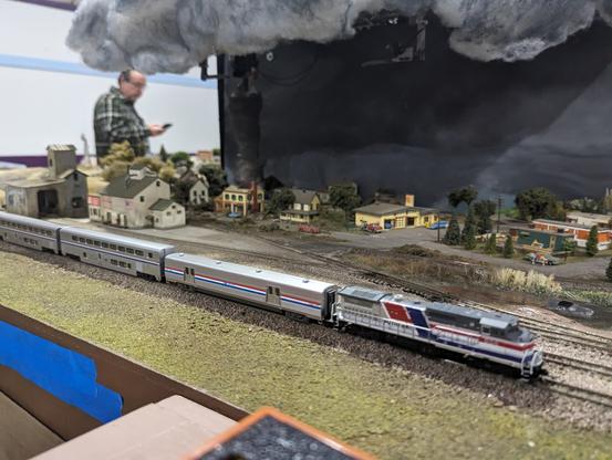 An Amtrak Pepsi Can locomotive passes by a tornado