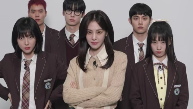 5 “high school” students in brown uniform jackets and their young teacher looking tough at the camera