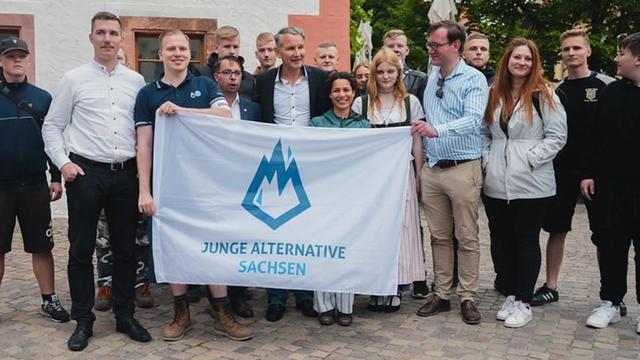 Gruppenbild der JA-Sachsen: Die festgenommenen Kurt Hättasch, Karl K., Jörn Schimanek, Jörg Schimanek und Hans-Georg Pförtsch gemeinsam mit Björn Höcke hinter einem Banner der "Junge Alternative Sachsen" am 21. Mai 2022 in Grimma. (Foto: Vue Critique)