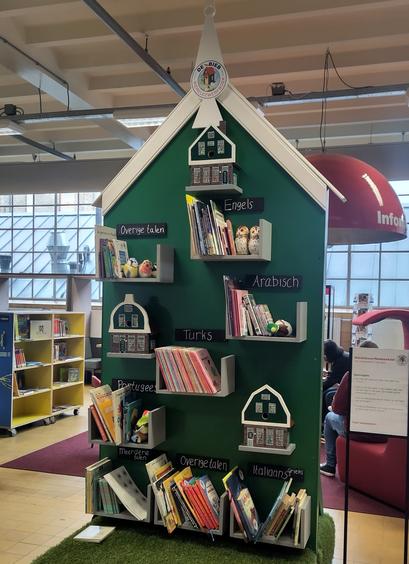 Boekenkast in de vorm van een Zaans huis, met boekenplanken voor verschillende talen.