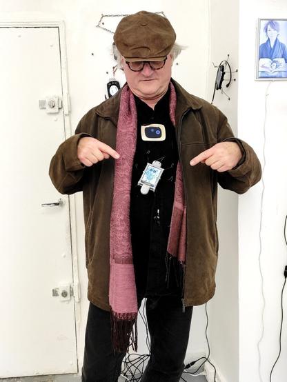 Reinhard Hampel, creator of the digital bug, with one of the bugs crawling up his belly, standing in front of the Sigrid Coggins exhibit.