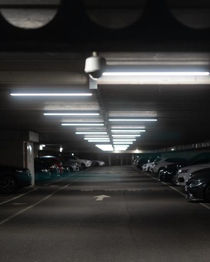 The roof of a carpark with fluorescent light tubes in alternating patterns.