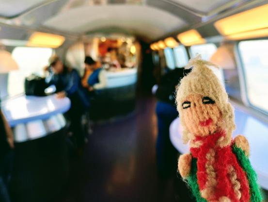 Finger puppet deciding on food in the dining car.