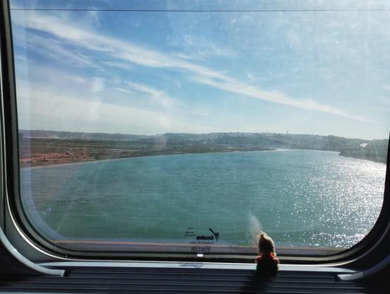 Finger puppet in a train window enjoying the view as the train crosses the Oued Bou Regreg.