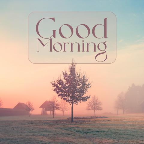The image shows a landscape with a "Good Morning" message. The background features a sunrise or sunset with a gradient sky of blue and orange hues. There is a field of grass in the foreground with trees scattered throughout. In the distance, there are buildings, possibly barns or houses, partially obscured by fog. The text "Good Morning" is displayed in an elegant font within a rounded rectangle near the top of the image.