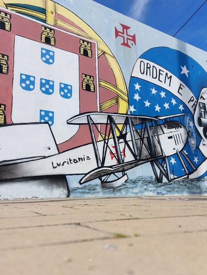 Mural com avião bimotor e bandeiras de Portugal e Brasil