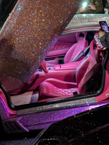 Left side view of the same Lamborghini with its door lifted showing the custom diamond tuck pink leather interior.